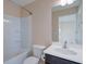 Bright bathroom with shower/tub combo, white sink, and dark-stained vanity at 6650 Canyon Cv, Cumming, GA 30028
