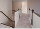 Hallway featuring white railing and trim, with gray carpeted floors leading to a doorway at 6650 Canyon Cv, Cumming, GA 30028