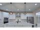 Beautiful kitchen with white cabinets, stainless steel appliances, an island, and pendant lighting at 6650 Canyon Cv, Cumming, GA 30028