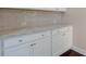 White cabinets and countertops add to the bright feel of this kitchen at 6650 Canyon Cv, Cumming, GA 30028