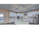 Bright kitchen features white cabinets, stainless steel appliances, and a large island with a marble countertop at 6650 Canyon Cv, Cumming, GA 30028