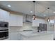 Modern kitchen with white cabinets, stainless steel appliances, marble countertops, and pendant lighting at 6650 Canyon Cv, Cumming, GA 30028