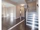 Bright living room featuring hardwood floors, elegant built-in shelves, and a staircase to the upper level at 6650 Canyon Cv, Cumming, GA 30028