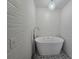 Bathroom with modern soaking tub featuring a tiled floor, wave wall tiles and chandelier at 9620 Carolina Dr, Jonesboro, GA 30238