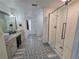 Primary bathroom with a double vanity, walk-in shower, and decorative patterned floor tiles at 9620 Carolina Dr, Jonesboro, GA 30238