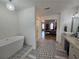 Open bathroom view to bedroom with soaking tub, shower, vanity, decorative tile and chandelier at 9620 Carolina Dr, Jonesboro, GA 30238