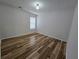This bedroom features wood floors, a window, and white walls at 9620 Carolina Dr, Jonesboro, GA 30238