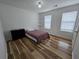 This bedroom has wood floors, white walls, and two windows at 9620 Carolina Dr, Jonesboro, GA 30238