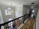 View of the foyer from the second floor with hardwood floors and decorative chandelier at 9620 Carolina Dr, Jonesboro, GA 30238