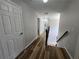 Hallway features hardwood flooring, white walls and trim and a staircase with dark wood banister at 9620 Carolina Dr, Jonesboro, GA 30238