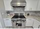 This kitchen features a stainless steel Viking range with a matching vent hood and white cabinetry at 9620 Carolina Dr, Jonesboro, GA 30238