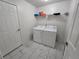 Bright laundry room with washer, dryer, and white marble floors at 9620 Carolina Dr, Jonesboro, GA 30238