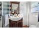 Bathroom with a brown vanity, shower with black and white tile, and natural light at 4983 Arcado Sw Rd, Lilburn, GA 30047