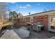 Wooden deck with a stainless steel gas grill, glass table, and chairs at 4983 Arcado Sw Rd, Lilburn, GA 30047