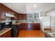 Kitchen with granite countertops, backsplash, dark cabinets, stainless steel appliances, and tile flooring at 4983 Arcado Sw Rd, Lilburn, GA 30047