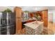 A spacious kitchen featuring an island with modern tile, granite countertops, and dark wood cabinetry at 4983 Arcado Sw Rd, Lilburn, GA 30047