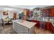 A spacious kitchen featuring an island with modern tile, granite countertops, and dark wood cabinetry at 4983 Arcado Sw Rd, Lilburn, GA 30047