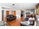 Spacious living room with orange tile flooring, leather sofas, and natural light at 4983 Arcado Sw Rd, Lilburn, GA 30047