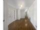 Long hallway with hardwood floors, white walls, and multiple doorways leading to various rooms at 5926 Brassie Ridge Ln, Ellenwood, GA 30294