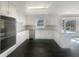 Modern kitchen with white cabinets, stainless steel appliances, stone countertops, and black tile floors at 5926 Brassie Ridge Ln, Ellenwood, GA 30294
