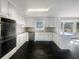 Modern kitchen with white cabinets, stainless steel appliances, stone countertops, and black tile floors at 5926 Brassie Ridge Ln, Ellenwood, GA 30294
