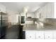 Bright kitchen with white cabinets, granite countertops, modern appliances and black tile floors at 5926 Brassie Ridge Ln, Ellenwood, GA 30294
