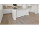 Modern kitchen with white cabinetry, a central island, stainless appliances, and wood-look floors at 2634 Mourning Dove Drive (Lot 41), Grayson, GA 30017