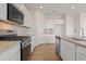 Modern kitchen with granite countertops, stainless appliances, an island, and wood-look floors at 2634 Mourning Dove Drive (Lot 41), Grayson, GA 30017