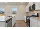 Modern kitchen with granite counters, stainless appliances, an island, and wood-look floors at 2634 Mourning Dove Drive (Lot 41), Grayson, GA 30017