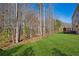 Spacious backyard featuring well-maintained lawn, wooden fence, deck, and backdrop of mature trees at 3610 Ansley Manor Ct, Cumming, GA 30028