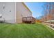 Backyard with a well-maintained lawn, a wooden deck, a fence, and mature trees in the background at 3610 Ansley Manor Ct, Cumming, GA 30028