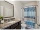 Bathroom with granite countertops, undermount sink, framed mirror and shower with colorful curtain at 3610 Ansley Manor Ct, Cumming, GA 30028