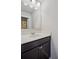 Bathroom vanity with a white countertop, undermount sink, and a dark brown cabinet with modern hardware at 3610 Ansley Manor Ct, Cumming, GA 30028