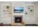 Living room fireplace with stone surround, mantel, built-in shelving, and lower cabinets at 3610 Ansley Manor Ct, Cumming, GA 30028