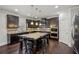 Gourmet kitchen boasts dark cabinets, granite counters, stainless appliances, and kitchen island seating at 3610 Ansley Manor Ct, Cumming, GA 30028