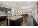 Gourmet kitchen with dark cabinets, granite counters, stainless appliances, and kitchen island seating at 3610 Ansley Manor Ct, Cumming, GA 30028