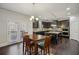 Dining and kitchen area boasting dark cabinets, granite counters, stainless appliances, and island seating at 3610 Ansley Manor Ct, Cumming, GA 30028