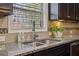 Up close picture of granite countertop, kitchen sink, and tiled backsplash at 3610 Ansley Manor Ct, Cumming, GA 30028