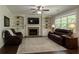 Comfortable living room with ceiling fan, stone fireplace, and built-in shelving and cabinets at 3610 Ansley Manor Ct, Cumming, GA 30028