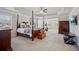 Bright main bedroom with tray ceiling, four poster bed, sitting area, and neutral carpet at 3610 Ansley Manor Ct, Cumming, GA 30028