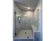 A modern shower featuring frameless glass doors and marble-look tile and a built-in bench at 400 Renwood Trl, Johns Creek, GA 30097