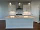 Modern kitchen featuring an island with sink, stylish lighting, and stainless-steel appliances at 400 Renwood Trl, Johns Creek, GA 30097