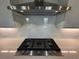 Close-up of the gas range and stainless steel KitchenAid vent hood, set against a white tile backsplash at 400 Renwood Trl, Johns Creek, GA 30097