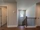 Stairway landing with wood floors, a window, and dark railing spindles at 400 Renwood Trl, Johns Creek, GA 30097