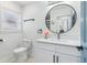 Modern bathroom featuring a vanity with a round mirror, a toilet, and a window at 5901 Miller Rd, Austell, GA 30106
