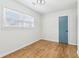 Well-lit bedroom with wood floors, a window providing ample natural light, and a blue accent door at 5901 Miller Rd, Austell, GA 30106