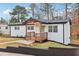 Well-maintained white brick home featuring a charming front porch and manicured lawn at 5901 Miller Rd, Austell, GA 30106