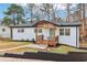 Charming renovated single-story home with brick exterior, wood porch and turquoise door at 5901 Miller Rd, Austell, GA 30106