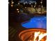 Backyard pool with a fire pit, string lights, lush landscaping, and comfortable lounge chairs at 820 Nob Ridge Dr, Marietta, GA 30064
