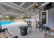 Inviting covered patio featuring a fire pit, ceiling fan, lounge furniture, and backyard view with a beautiful pool at 820 Nob Ridge Dr, Marietta, GA 30064